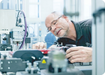 Techniker prüft präzise Bauteile an einer Maschine in der Fertigung