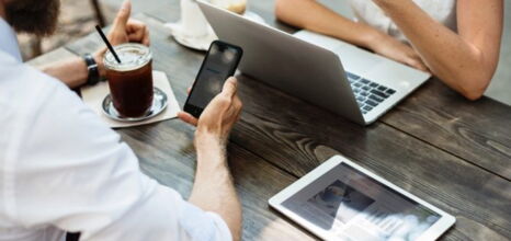 Personen mit Handy, Tablet und Laptop