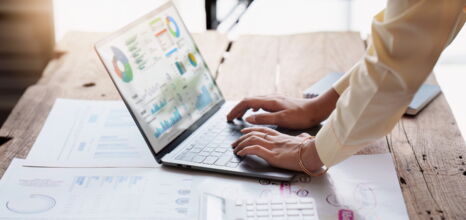 Laptop mit zwei Händen die darauf arbeiten