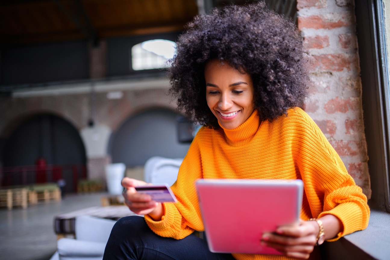 Frau mit Tablet und Kreditkarte in der Hand