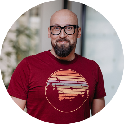 Mann mit Bart und Brille im roten T-Shirt mit Sonnenuntergangs-Motiv